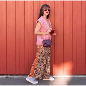 Detailed close-up of pink plaid sleeveless vest paired with a quilted purple crossbody bag