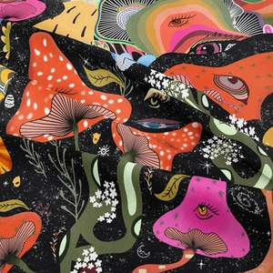 Detailed close-up showing vibrant psychedelic mushroom patterns on soft bohemian tapestry fabric