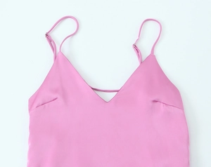 Détail du caraco en satin rose montrant le col en V et la texture lisse du tissu