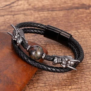 Detail of men's leather bracelet featuring silver dragon heads and tiger eye stone bead