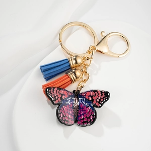 Golden butterfly keychain with colorful drip oil pendant and vibrant fabric tassels