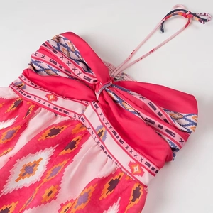 Detail of pink ethnic pattern halter dress featuring a front bow and geometric prints