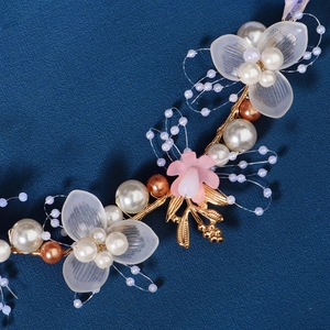 Handmade bridal headband with white flowers, gold leaves and pearls on navy background