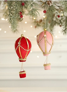 Detailed view of velvet hot air balloon Christmas ornaments with pearls and gold accents
