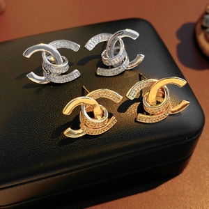 Macro detail of intertwined 18k gold and silver earrings with sparkling crystals