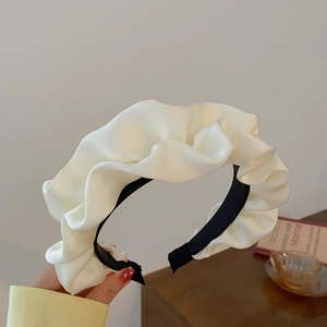 Close-up of cream white pleated bow headband with non-slip inner lining for women