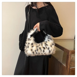 Close-up of leopard print plush crescent bag featuring faux fur texture and black strap