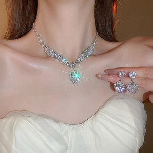 Detail of silver V-shaped necklace and matching heart earrings with sparkling crystals