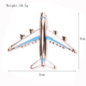Creative gold airplane brooch with blue enamel wings and 4cm by 5cm size dimensions