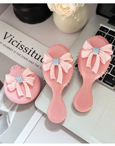 Detailsicht des rosa Haarbürsten-Sets mit faltbarem Spiegel und Maschen-Design
