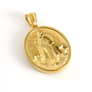 Macro shot of gold-plated oval pendant with detailed Virgin Mary religious relief carving