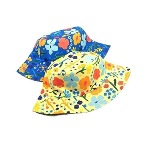 Detail of vibrant floral print cotton sun hats for children in blue and yellow colors