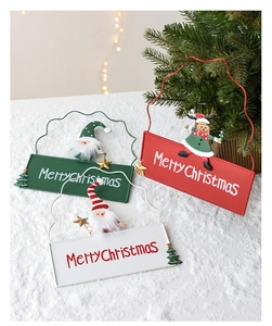 Close-up of metal Christmas signs featuring Santa and reindeer on snowy backdrop
