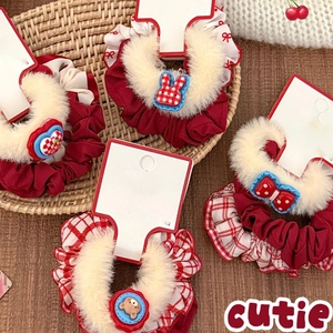 Plush polka dot scrunchie set with cartoon charms on a rustic woven tray