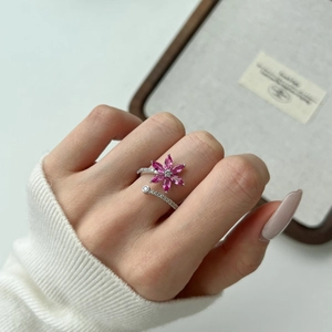 Close-up of elegant S925 silver ring featuring a pink gemstone flower on woman's hand