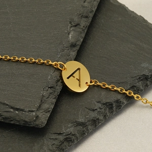Bracciale minimalista con ciondolo lettera A in oro 18k su sfondo in pietra
