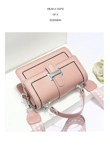Pink crossbody bag detail with contrast stitching, metal lock and printed wide strap