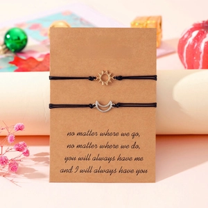 Detail of sun and moon pendants on adjustable black cords with Best Friends card