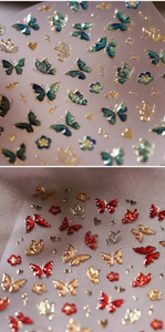 Vue macro détaillée de stickers d'ongles 3D en relief avec papillons et bordures dorées