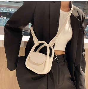 Sac à main blanc mini design avec poignée intégrée et fine bandoulière porté sur mannequin
