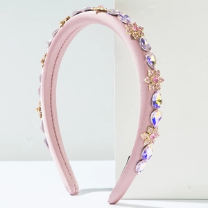 Details des gepolsterten rosa Stirnbandes mit lila Kristallen und goldenen Blumenakzenten