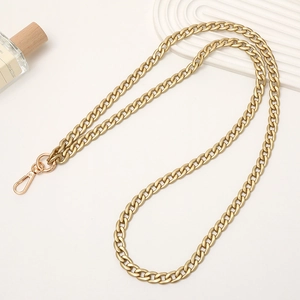 Flat gold metal phone lanyard chain with lobster clasp on white elegant tabletop