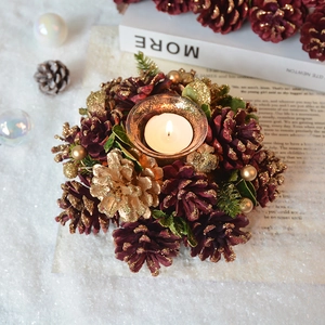 Vintage pine cone Christmas candle holder with red berries and warm festive light