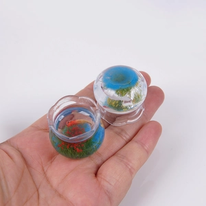 Close-up of miniature resin fish tank charm featuring koi fish and green water plants