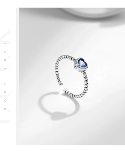 Detailed macro of vintage s925 silver ring featuring heart blue stone and braided band