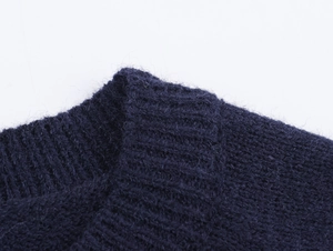 Detailed close-up of dark blue rib-knit fabric texture with soft wool-like fuzzy fibers
