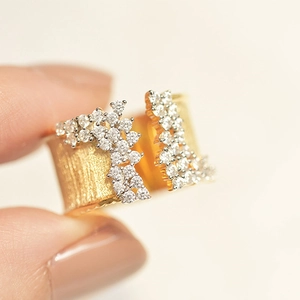 Macro shot of gold-plated ring showing brushed metal texture and cluster zircon setting