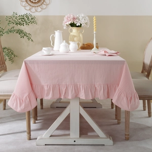 Detail of pink cotton linen tablecloth featuring decorative ruffled edges for weddings