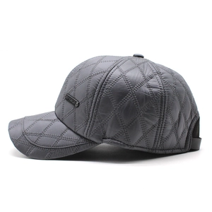 Close-up of diamond-quilted winter baseball cap with metal logo plate in dark grey