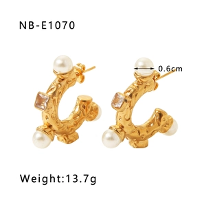 Détail de boucles d'oreilles en C plaquées or 18k avec texture martelée et perles