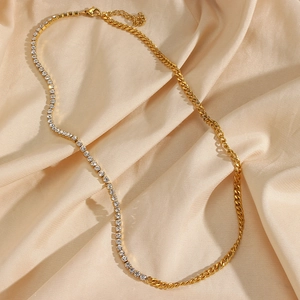 Detail of gold spliced Cuban link necklace with zircon accents on pink silk fabric
