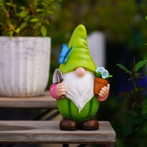 Gartenzwerg-Statue mit Schmetterling und Schaufel hält einen Blumentopf für die Gartendeko