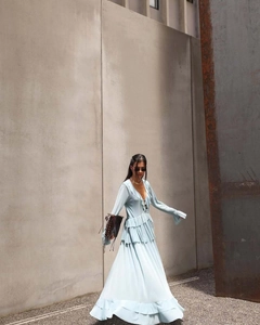 Detail of light blue bohemian maxi dress with ruffled layers and a V-neck design