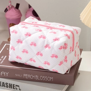 Trousse à cosmétiques blanche matelassée avec nœuds roses et fermeture éclair de voyage