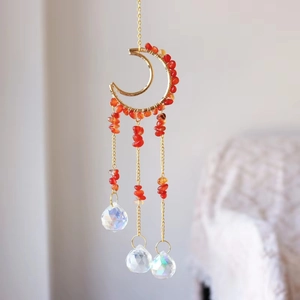 Macro detail of golden crescent moon frame with red agate stones and crystal glass balls