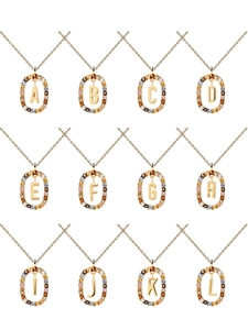Macro view of crystal-encrusted oval pendants featuring golden initial alphabet letters