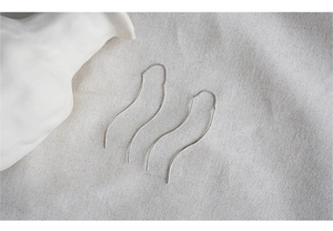 Close-up of elegant S-shaped silver drop earrings on a minimalist linen background