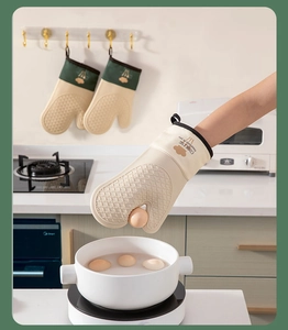 Detail of beige silicone oven mitt with diamond texture and green fabric wrist cuff