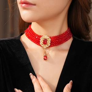 Detail of vintage red bead choker with gold relief ornament and ruby pendant