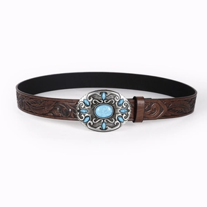 Detailed view of brown leather belt with leaf embossing and blue turquoise buckle