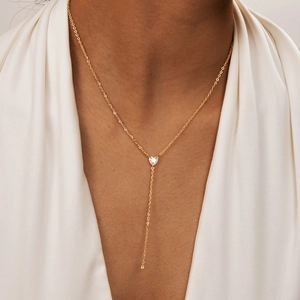 Elegant gold Y-shaped necklace with heart-shaped zircon pendant on a model's neck
