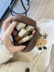 Brown suede chestnut pouch with cute croissant plush charm showing internal capacity