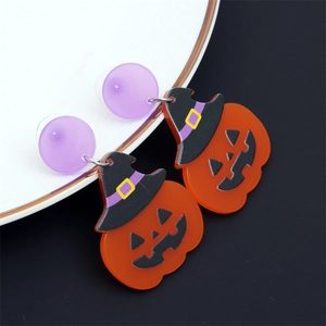 Détail macro de boucles d'oreilles citrouille d'Halloween avec clous violets
