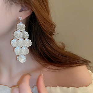 Detail of layered white petal shell fringe earrings with sparkling round crystal stud