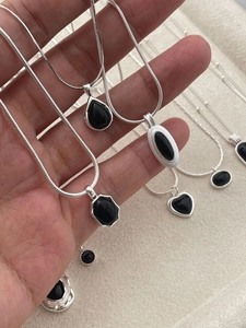 Detailed close-up of S925 silver necklaces with black agate heart and water drop pendants