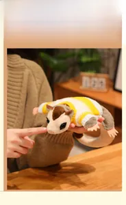 Detailed view of sugar glider plush toy wearing a yellow and white striped sweater